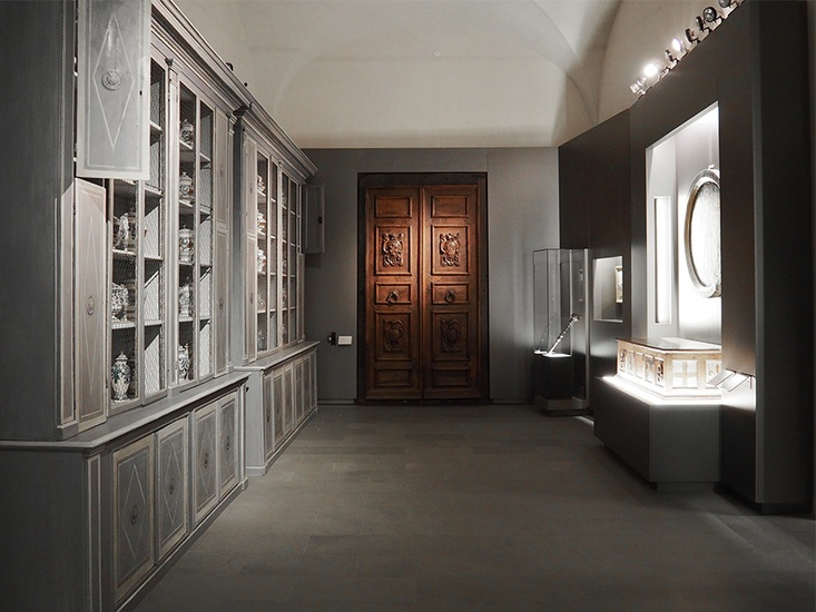 Una sala del piano terra con portone in legno e mobile da farmacia